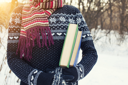 50629836 - girl in a wool sweater keeps old books.